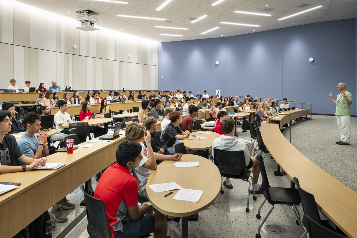 Students sit at desks and tables listening to an instructor in Levy Hall.
