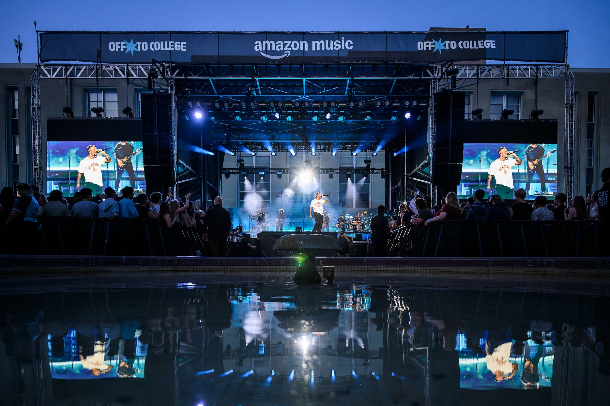 Kane Brown performs on a large stage, with a crowd and fountain in the foreground.