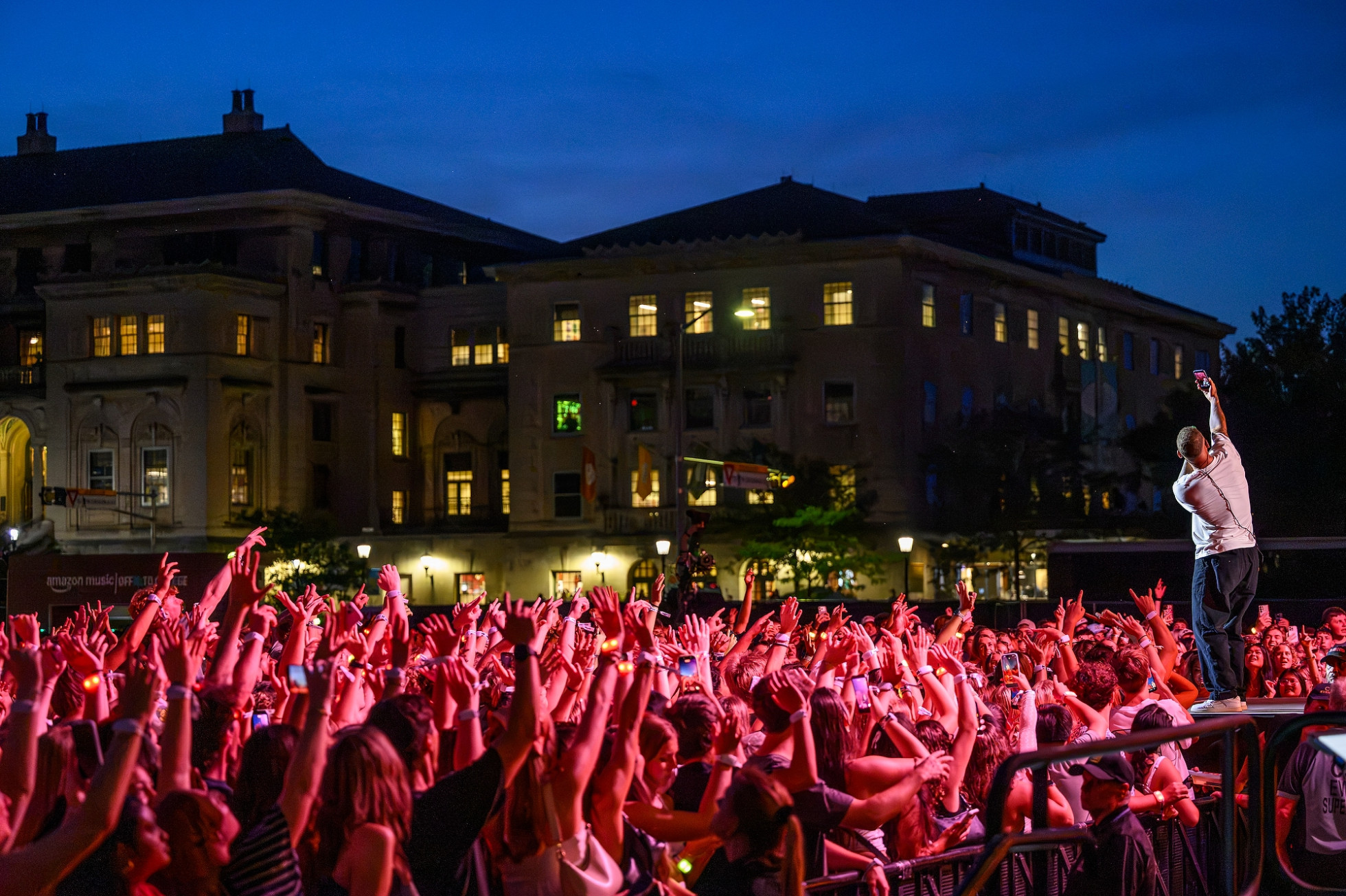 Kane Brown takes a selfie on stage with the crowd in the background. 