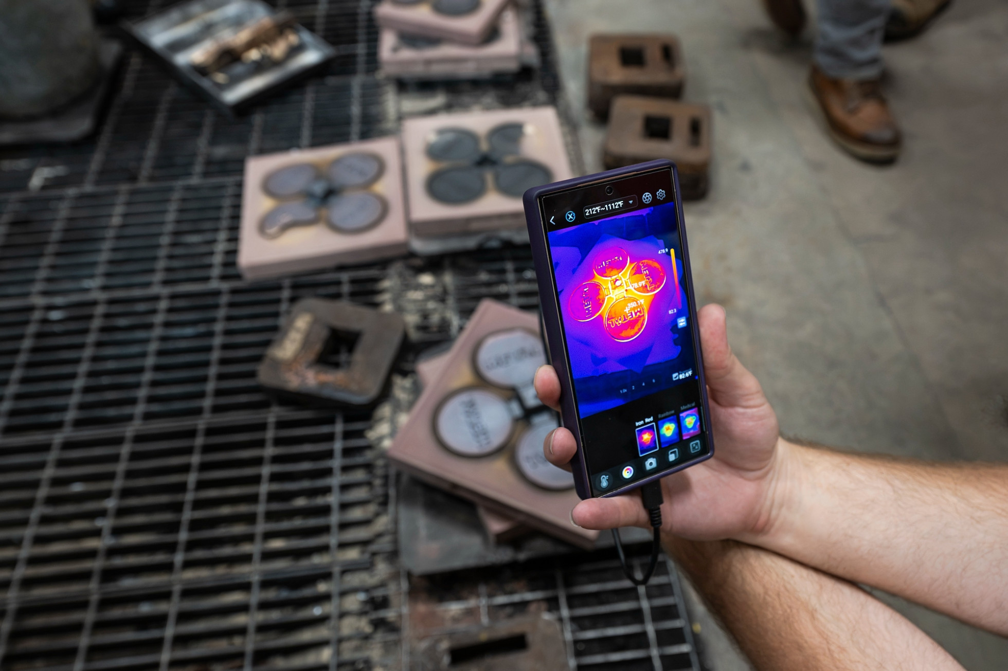 A photograph taken by phone shows the heat sensing of the hot metal being cast in a mold.