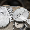 Silver aluminum medallions sit on a work station after being cast and cut.