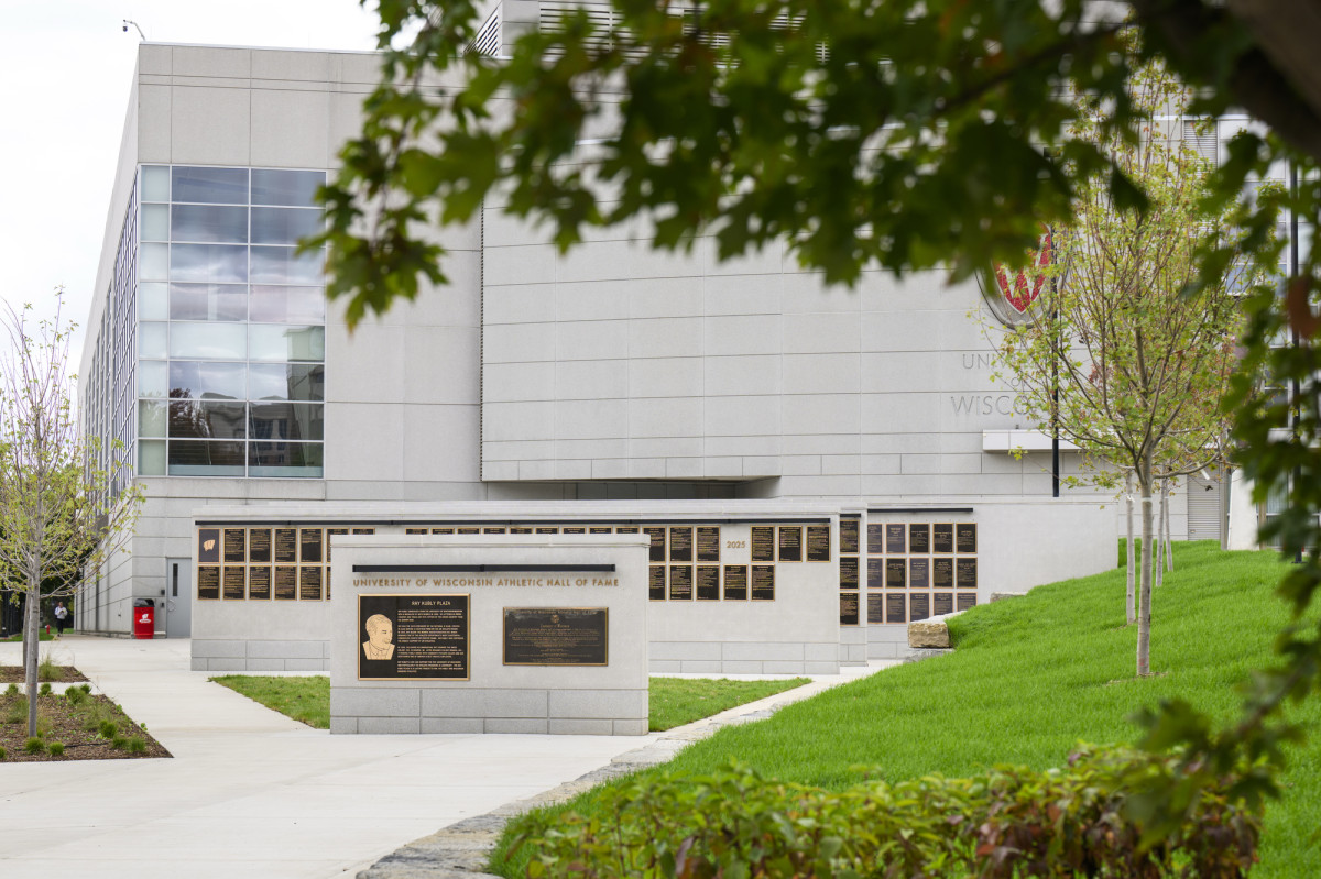 The UW Athletic Hall of Fame's concrete walls and bronze plaques, with the Kohl Center in the background.