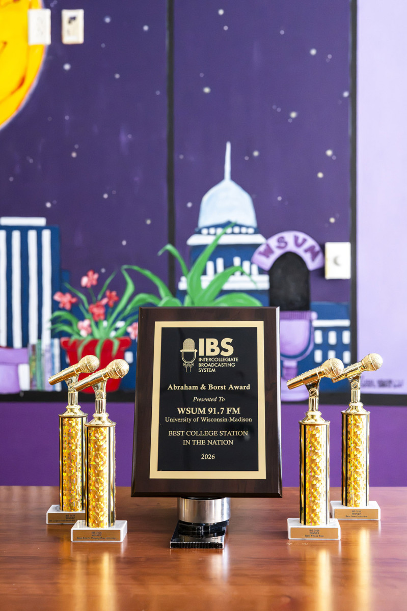 Awards WSUM has received sit in front of a colorful mural depicting the state capitol building and a black cat