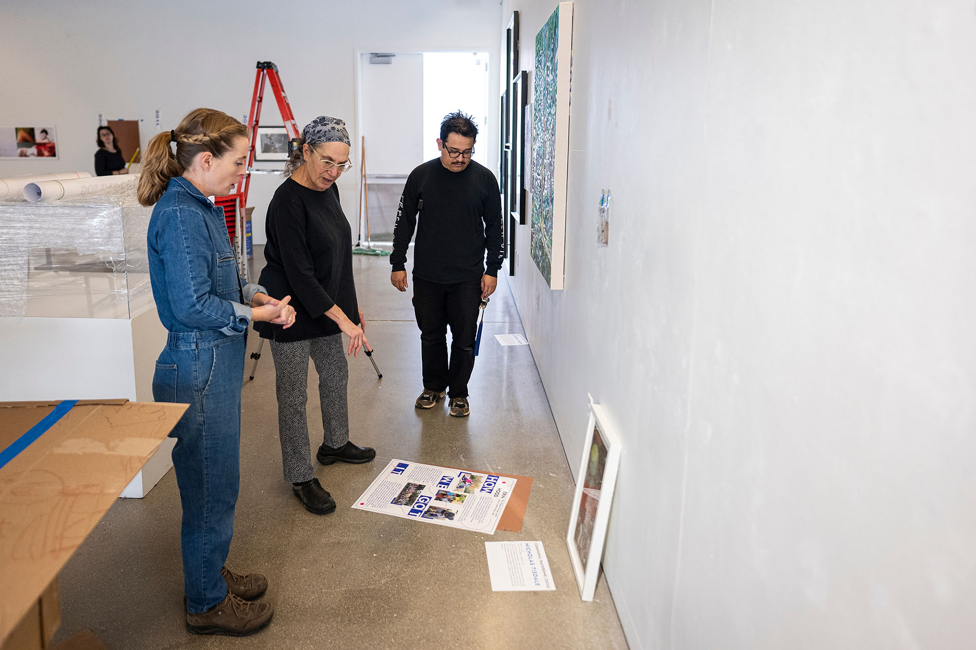 Laurie Beth Clark and alum artist Emily Belknap chat while looking at her art pieces ready to hang