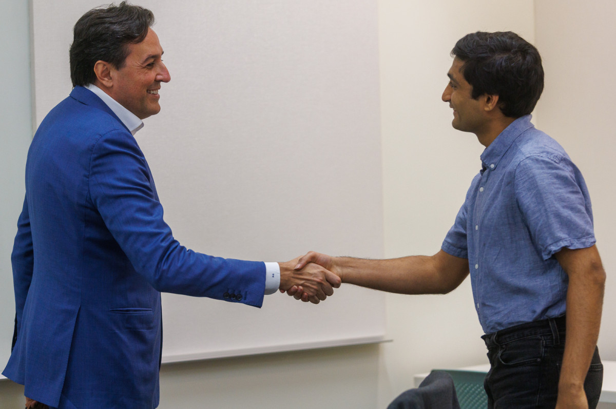 Darío Gil, under secretary for science at the U.S. Department of Energy, shakes hands with Stavan Jain, a doctoral student in computer sciences at the University of Wisconsin–Madison.