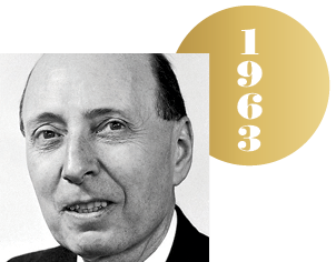 Black and white headshot of Har Eugene Wigner with an overlapping gold circle representing a Nobel medal, with the year 1963 on it.