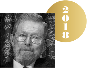 Black and white headshot of George P. Smith with an overlapping gold circle representing a Nobel medal, with the year 2018 on it.