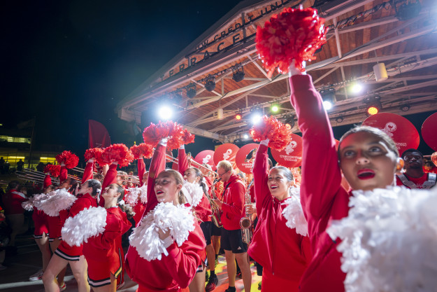 The UW Spirit Squad raises their poms in the air during a musical number that is part of the Homecoming pep rally on the Memorial Union Terrace.