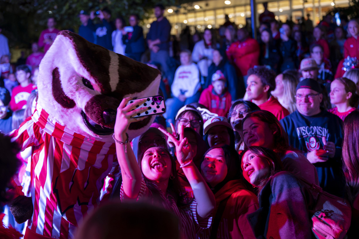 A group of young women take a selfie with Bucky Badger.