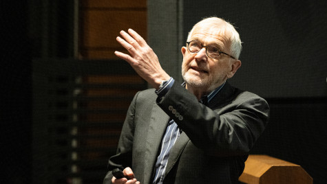 Professor Francis Halzen points toward a screen while giving a presentation.