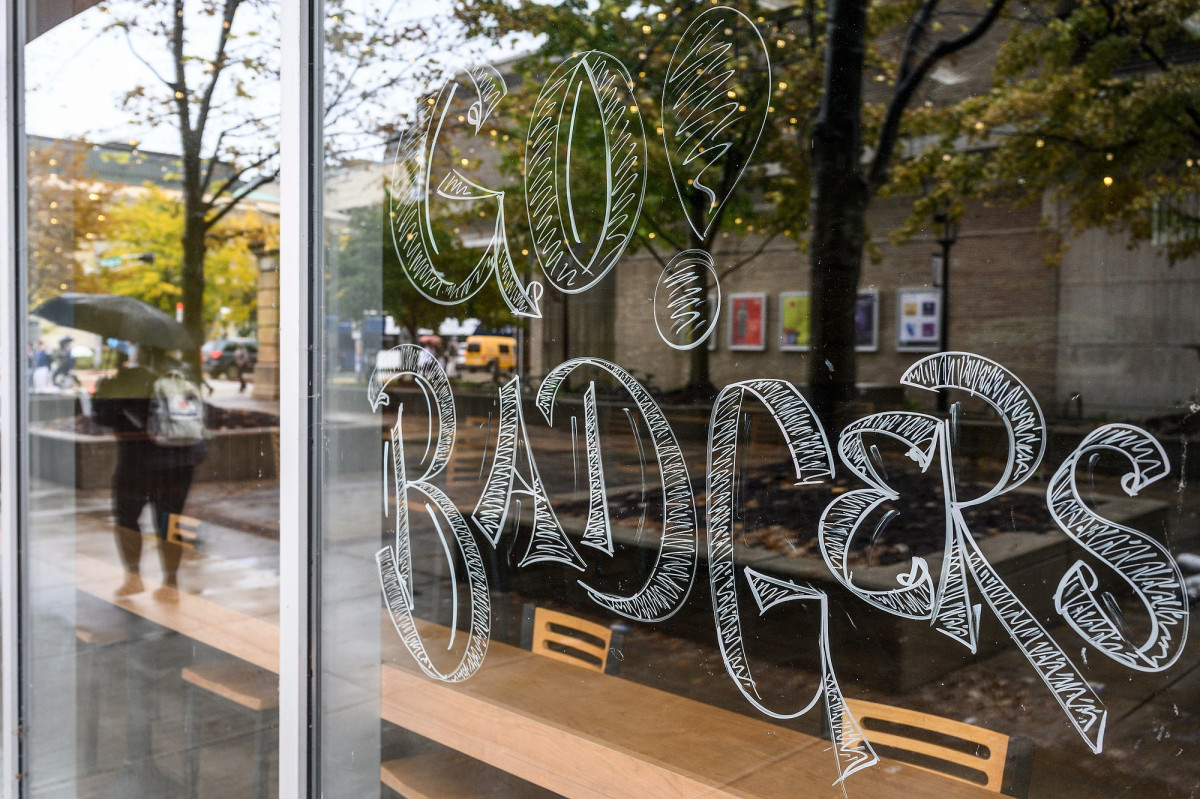 The words Go Badgers are painted in white marker on the windows of a building along East Campus Mall.